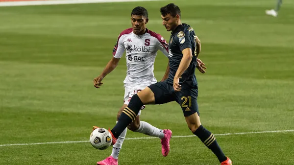 En un Ricardo Saprissa vacío por la pandemia de Covid-19, Jordy Evans intenta quitarle la bola a Anthony Fontana. (