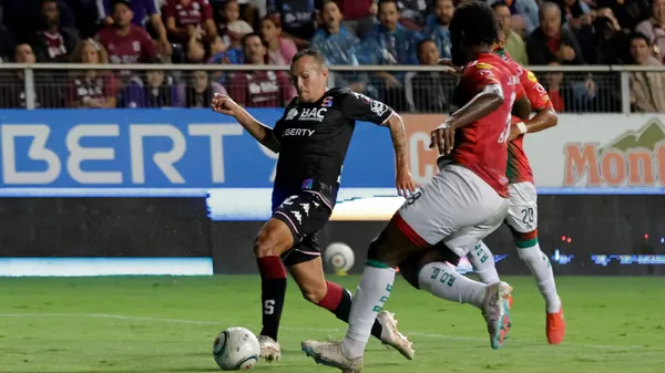 Klíver Gómez traslada la pelota ante el asedio de dos futbolistas de ADG. (