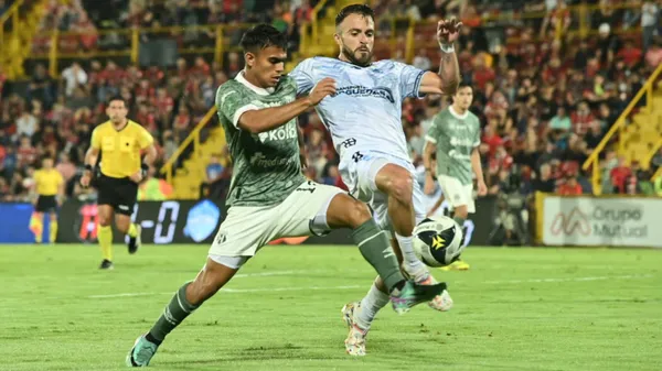Aarón Suárez y el seleccionado chapín Rodrigo Saravia se disputan la bola en el Morera Soto. (