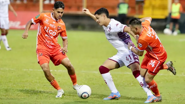 Warren Madrigal protege la bola de la marca de Pablo Herrera. (