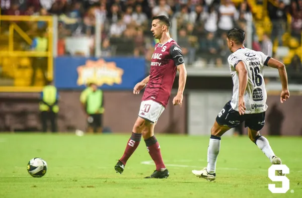 Mariano Torres pasa la bola antes de que llegue la marca de Christian Martínez. (