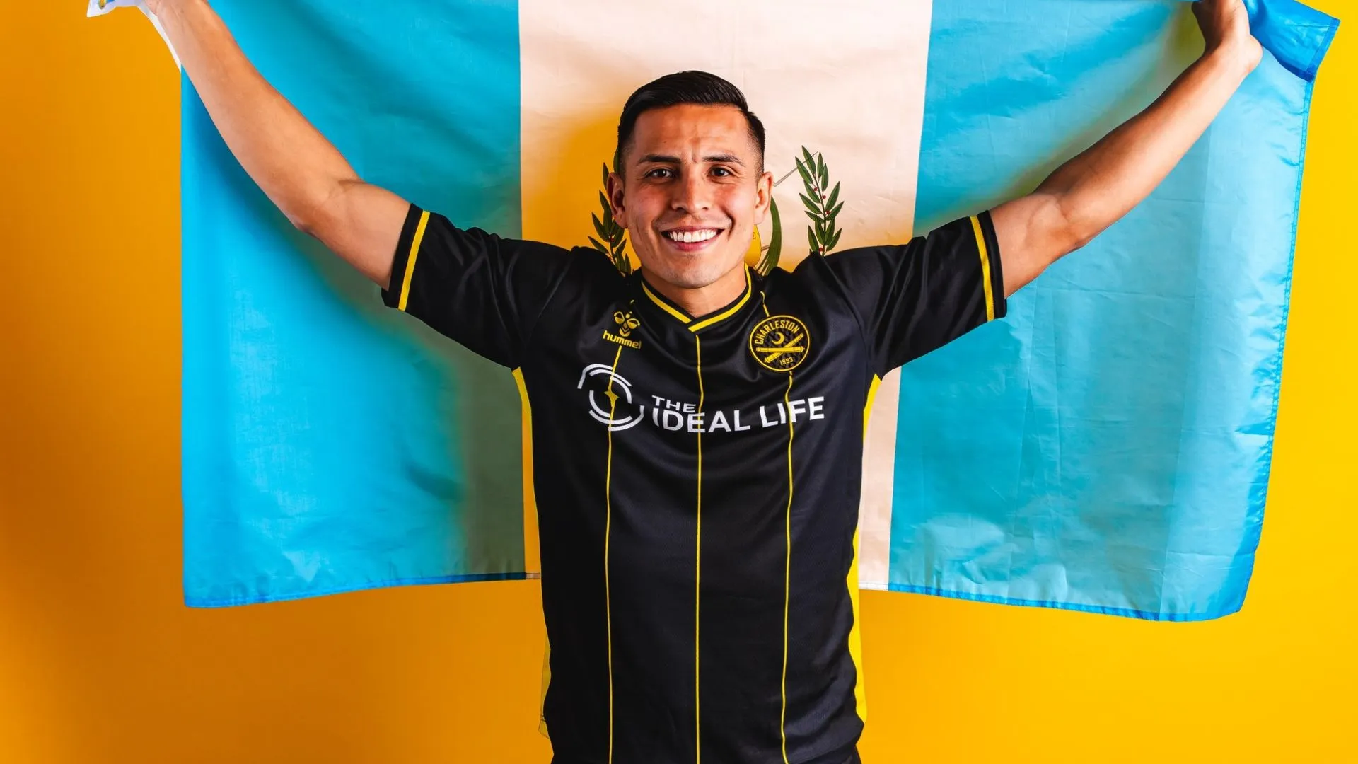 Rubio Rubín con la bandera de Guatemala y vistiendo la camisola del Charleston Battery.