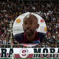 Paulo Wanchope en conferencia y la afición morada de fondo.