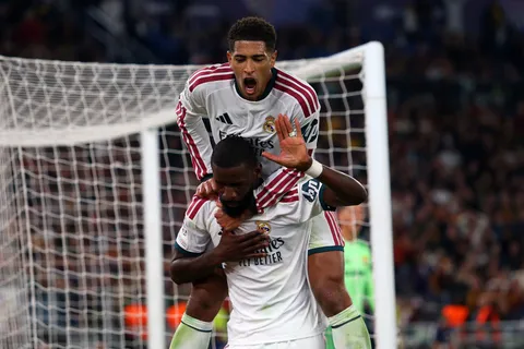 Bellingham se trepa a Rüdiger, quién selló la remontada de Real Madrid ante Roma.