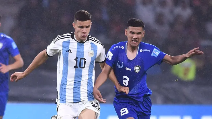 Valentin Carboni of Argentina fights for the ball with Bekhruzbek Askarov of Uzbekistan.