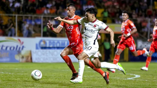 Leo Menjívar, seguido de cerca por Asdrúbal Gibbons, mientras trasladaba la esférica. (Foto: La Nación)