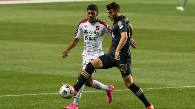 En un Ricardo Saprissa vacío por la pandemia de Covid-19, Jordy Evans intenta quitarle la bola a Anthony Fontana. (Foto: Mexsport)