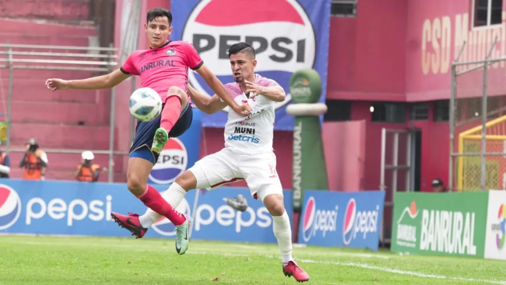 El “Flaco” Martínez protege la esférica ante la pegajosa marca de Wilson Godoy. (Foto: CSD Municipal)
