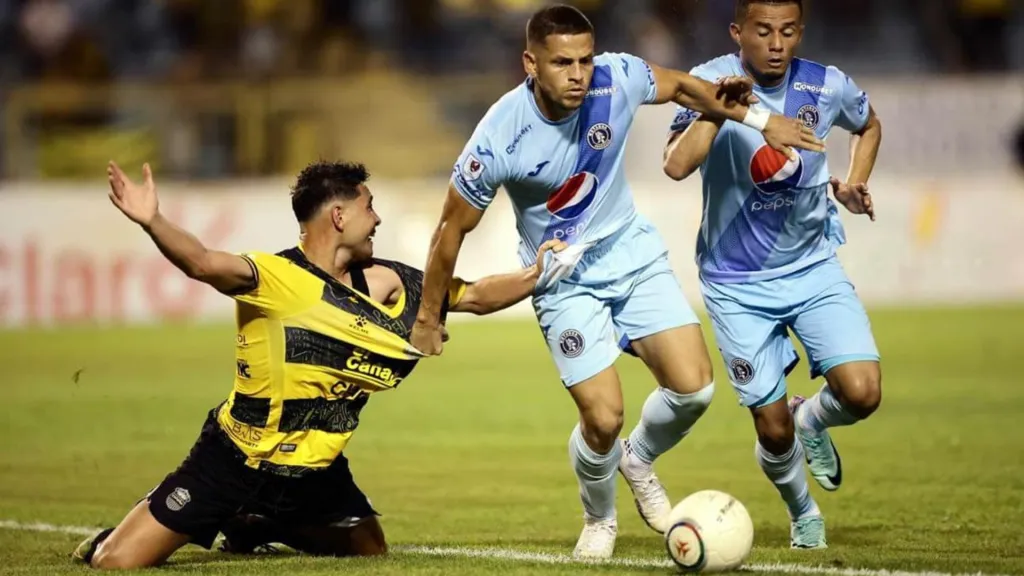 Marcelo Santos le gana el duelo por la pelota a Jhow Benavídez en el último Real España – Motagua.