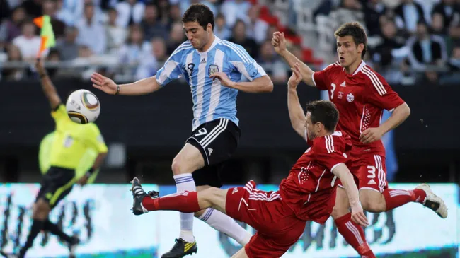 Gonzalo Higuaín protege la bola de la férrea marca de los seleccionados canadienses. (Foto: IMAGO)