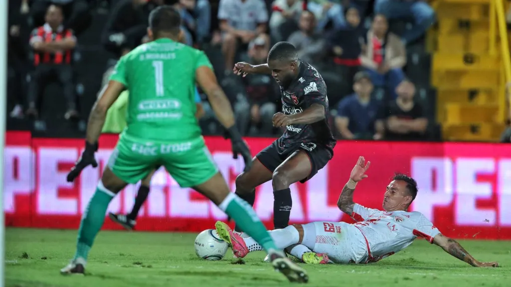 Rigoberto Jiménez se barre para intentar extirparle la bola a Joel Campbell, hoy en Goianiense de Brasil. (Foto. John Durán / La Teja)