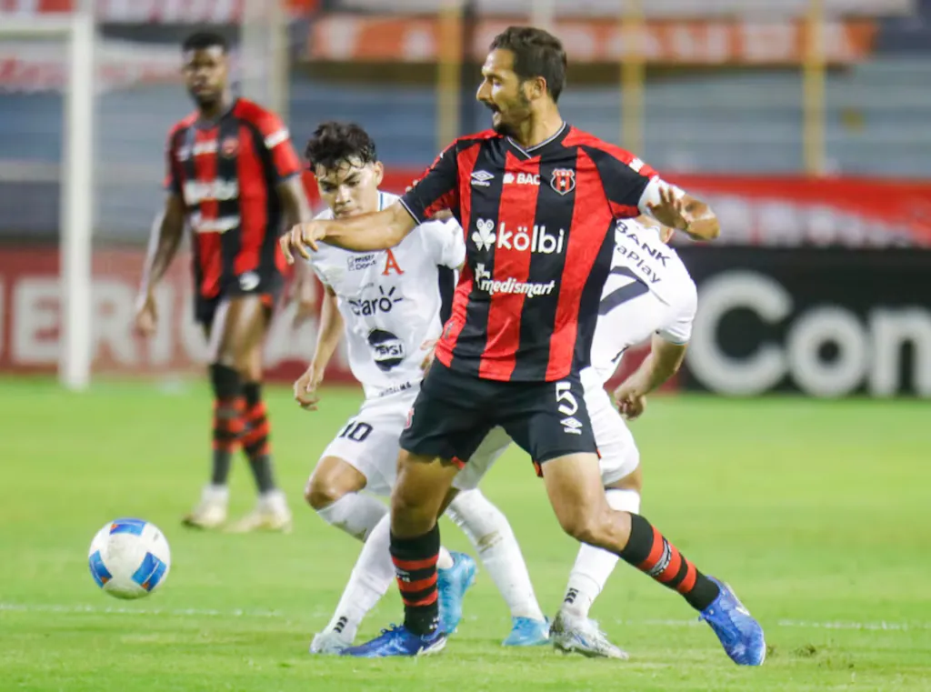 Leo Menjívar pelea por arrebatarle la bola a Celso Borges. (Foto: Concacaf.com)