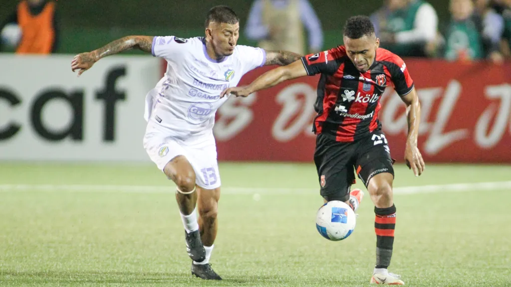Stheven Robles persigue a Ian Lawrence en el último Alajuelense-Comunicaciones. (Foto: Concacaf)