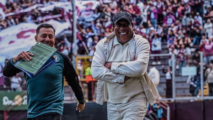 El DT morado sonríe.